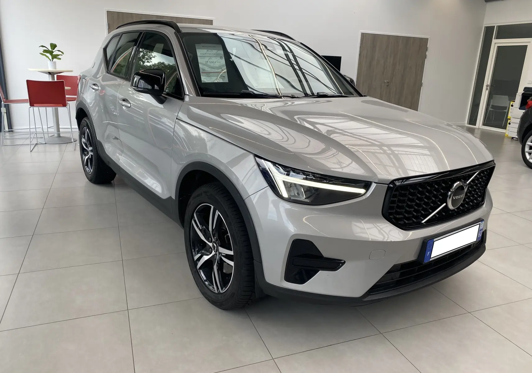 Volvo XC40 B3 163ch Plus 2023 en Argent Aurore métallisé, vue 3/4 avant avec calandre noire et jantes alliage.