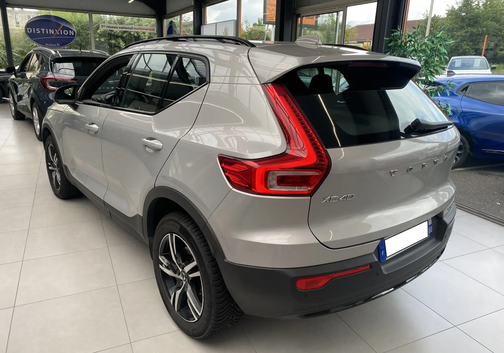 Vue 3/4 arrière droite du Volvo XC40 B3 163ch Plus 2023 en argent aurore métallisé, avec feux arrière LED caractéristiques.