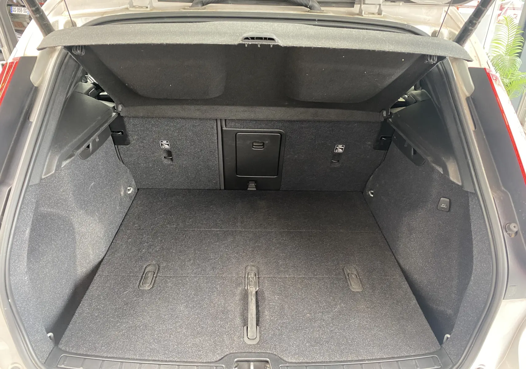 Coffre ouvert du Volvo XC40 B3 argent aurores métallisé, vue arrière montrant l'espace de chargement et la banquette rabattable.