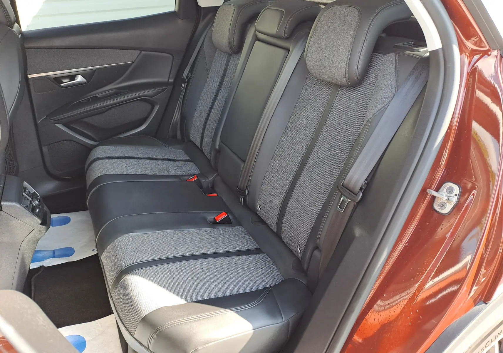 Vue intérieure côté arrière droit du Peugeot 3008 2019 metallic cooper, sièges arrière en tissu et cuir gris bicolore.
