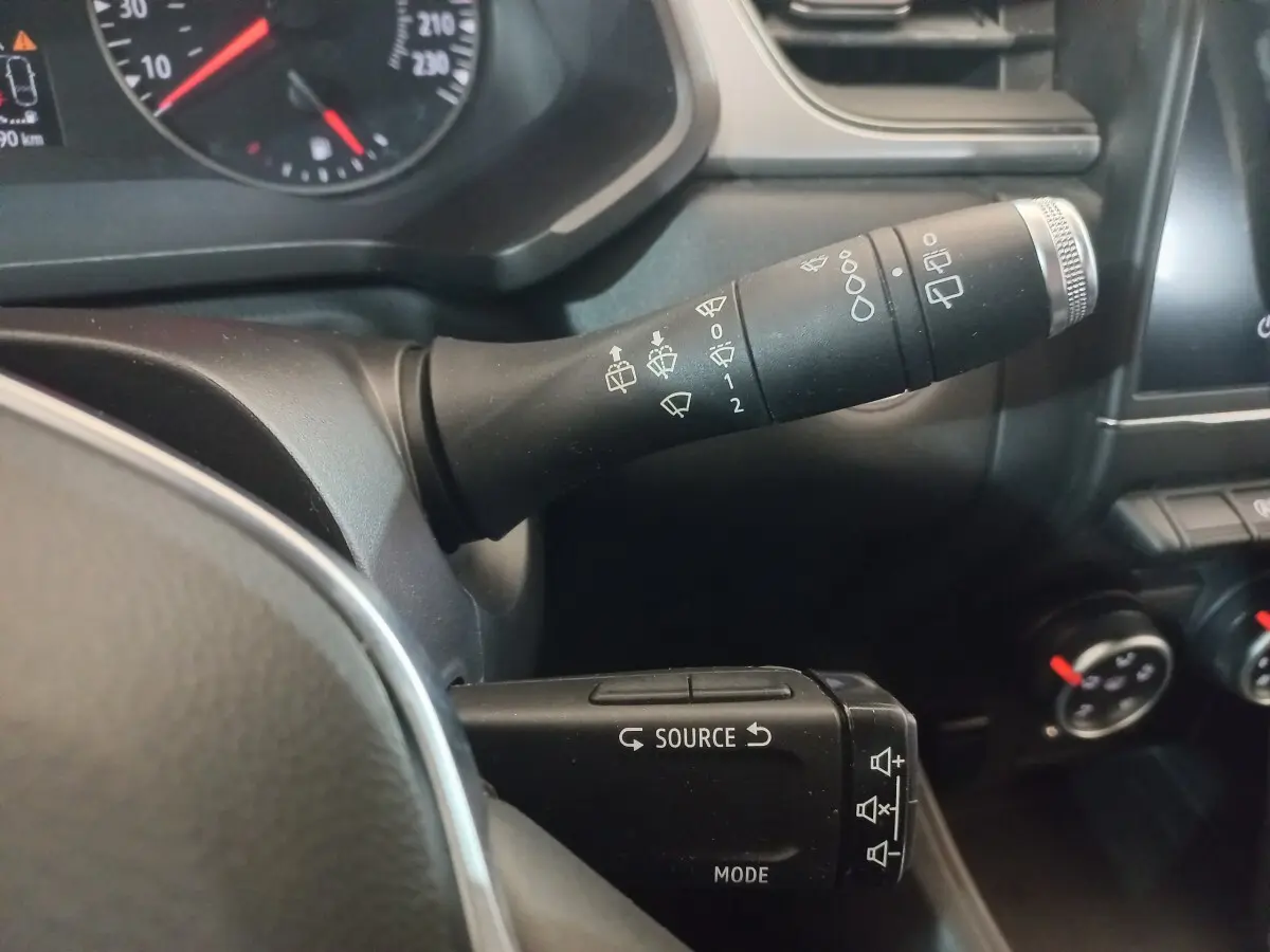 Gros plan sur les commandes au volant du Renault Captur gris clair 2020, avec leviers multifonctions et tableau de bord partiel.