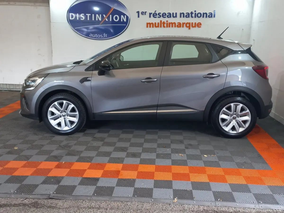 Profil droit d'un Renault Captur Business gris clair 2020, avec jantes alliage et rétroviseurs noirs dans un showroom.