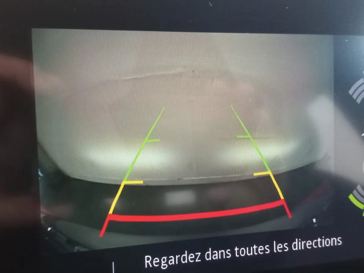 Vue arrière via caméra de recul du Renault Captur gris clair Business TCe 100 de 2020 avec lignes de guidage colorées.