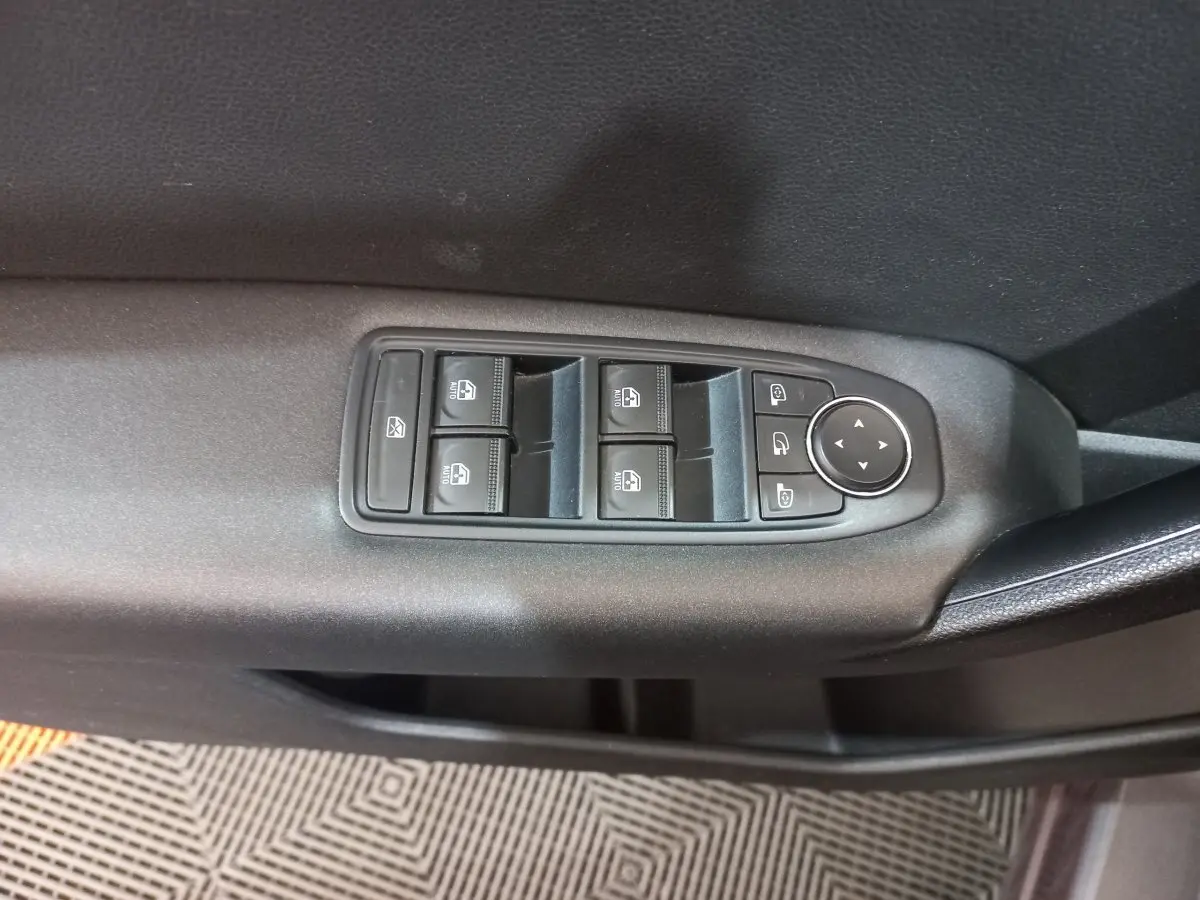 Panneau de commandes des vitres électriques et rétroviseurs sur la porte côté conducteur d'un Renault Captur gris clair 2020.