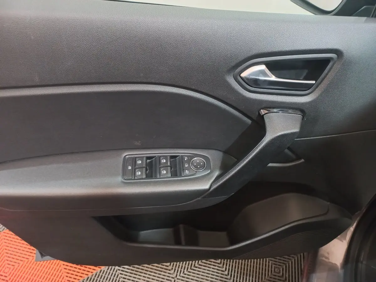 Poignée et commandes des vitres côté conducteur du Renault Captur Business TCe 100 gris clair, vue intérieure de la portière.