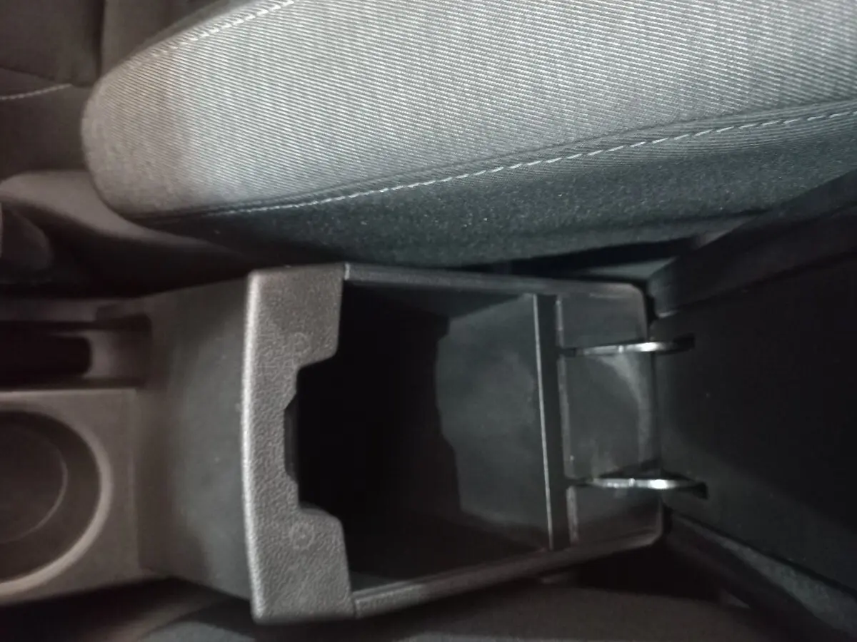 Vue rapprochée de la console centrale ouverte avec rangement, siège tissu gris clair du Renault Captur Business 2020.