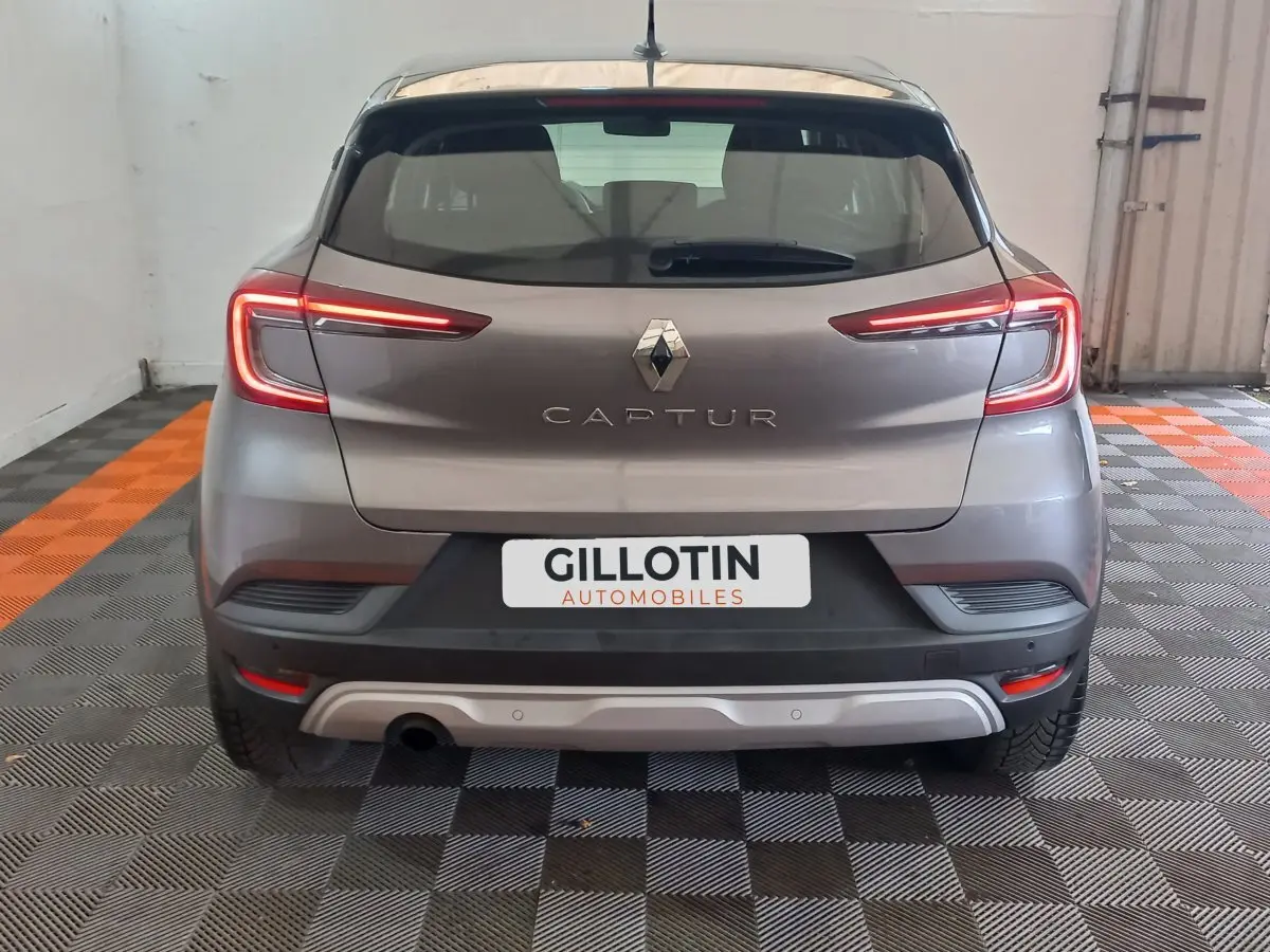 Vue arrière d'un Renault Captur gris clair avec feux LED allumés et plaque d'immatriculation GILLOTIN Automobiles.