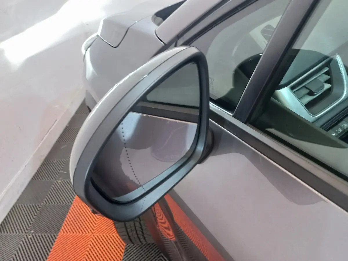 Rétroviseur côté gauche d'un Renault Captur Business gris clair, avec partie de la portière et intérieur visible.