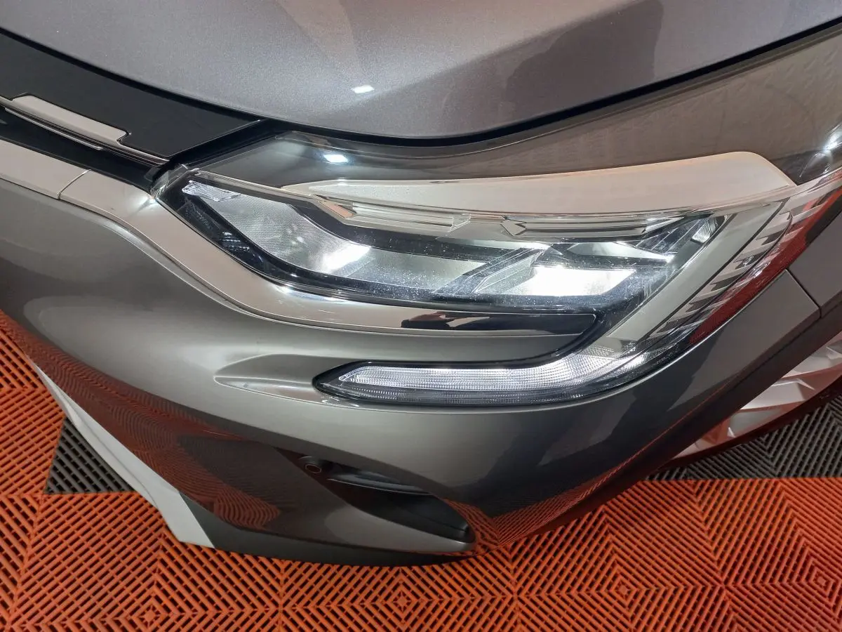Gros plan sur le phare avant droit du Renault Captur Business gris clair, mettant en valeur ses feux LED modernes.