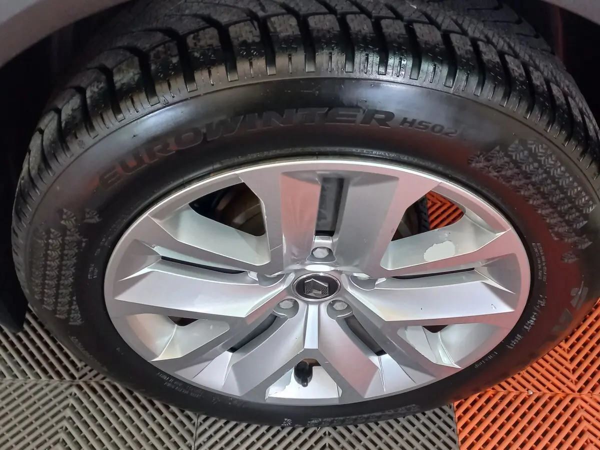 Gros plan sur la roue avant gauche d'un Renault Captur Business gris clair, montrant le pneu et la jante.