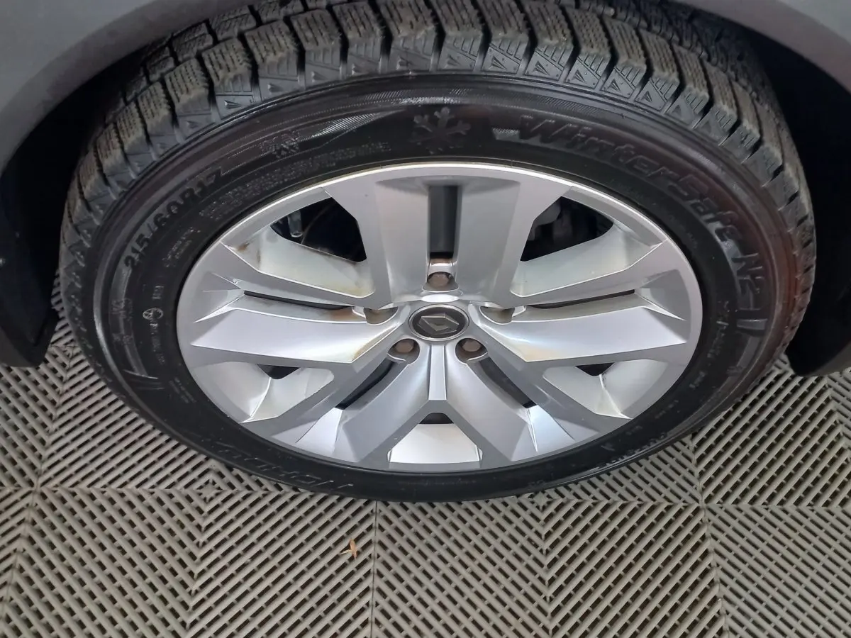 Gros plan sur la roue avant droite du Renault Captur Business gris clair avec jante alliage et pneu hiver