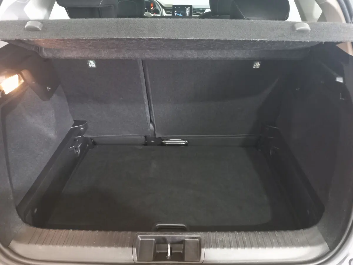 Coffre ouvert en vue arrière du Renault Captur Business TCe 100 gris clair, montrant l'espace de chargement vide.