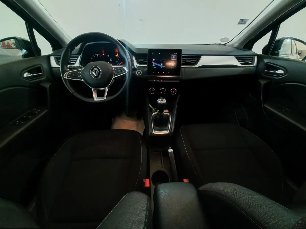 Vue intérieure frontale du Renault Captur Business 2020, tableau de bord noir avec écran tactile central et volant multifonctions.