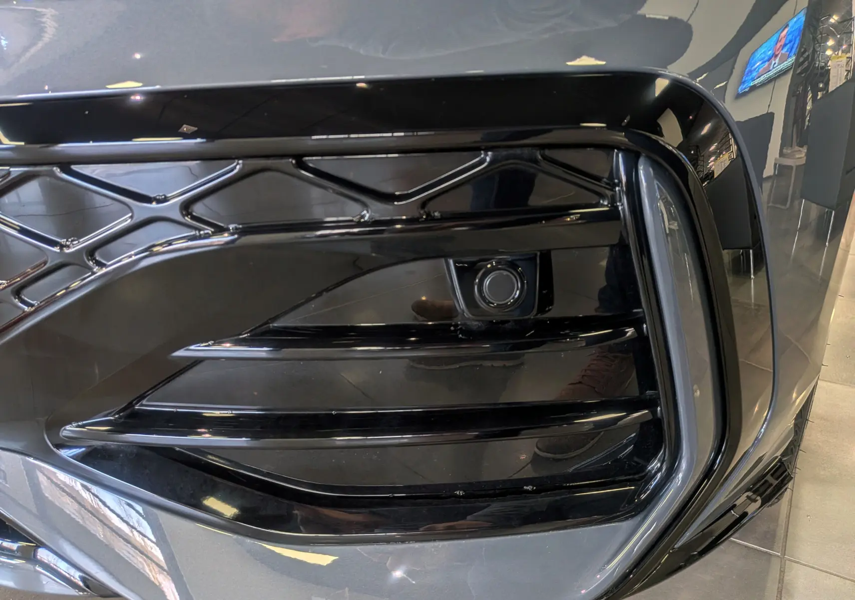 Gros plan sur la calandre avant noire brillante de la Volkswagen Golf 1.5 eTSI gris Dauphin, version R-Line Limited 2025.