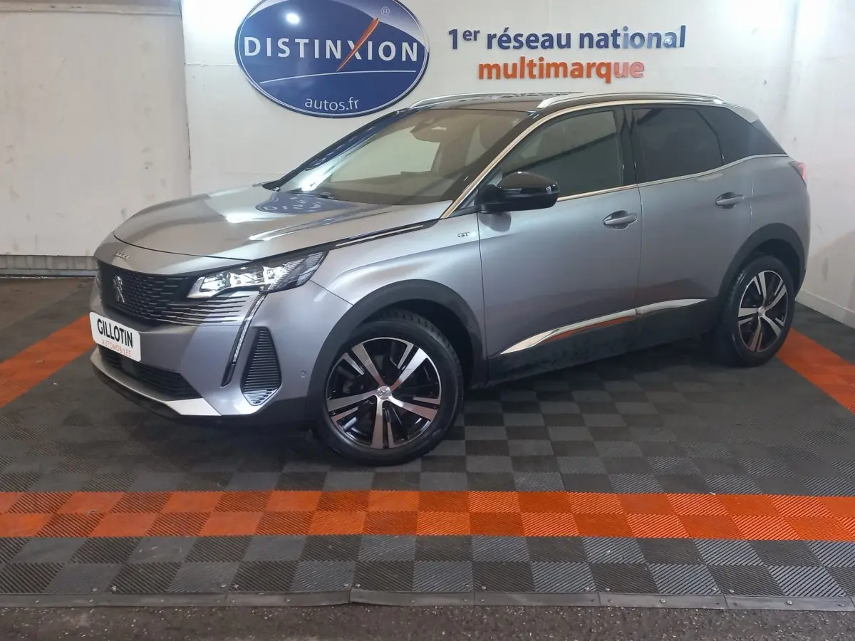 Peugeot 3008 gris clair en vue 3/4 avant droit, avec jantes noires et détails chromés sur les bas de caisse.