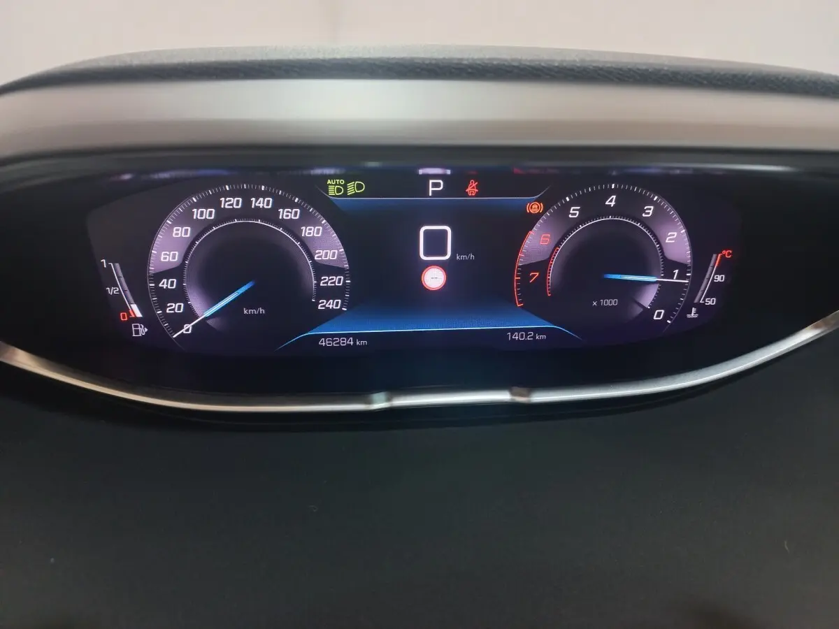 Affichage numérique du tableau de bord du Peugeot 3008 gris clair, montrant vitesse, compte-tours et jauge carburant.