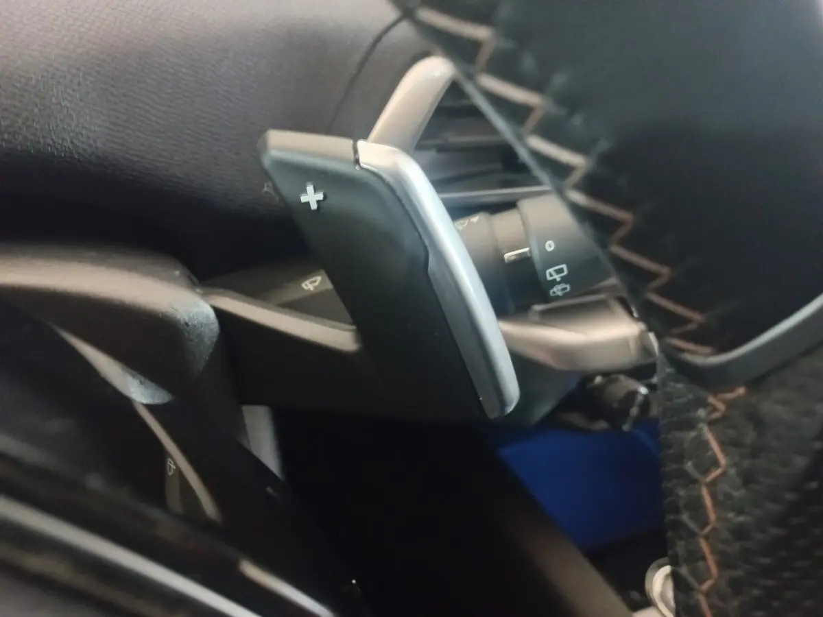 Gros plan sur la palette de changement de vitesse "+" côté droit du volant cuir du Peugeot 3008 gris clair 2022.