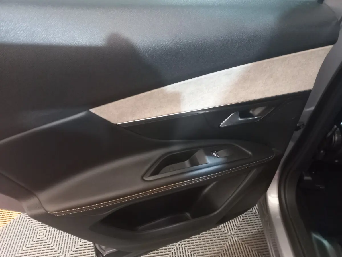 Vue intérieure côté gauche de la porte arrière grise du Peugeot 3008 2022 avec garniture noire et beige et commande de vitre.