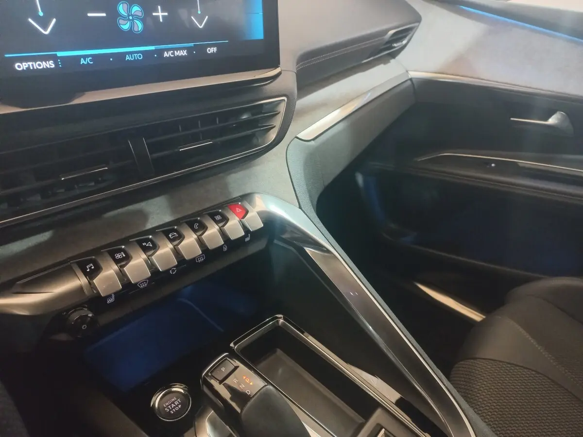 Vue intérieure côté passager du tableau de bord et console centrale du Peugeot 3008 GT gris clair avec écran tactile et commandes.