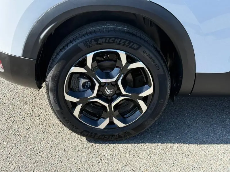 Gros plan sur la roue avant gauche du Citroën C5 Aircross blanc Okénite 2025 avec jante alliage noire et argentée.