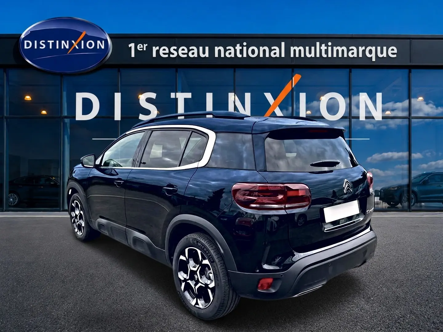Vue 3/4 arrière droite d'un Citroën C5 Aircross noir 2025 devant une vitrine Distinxion.