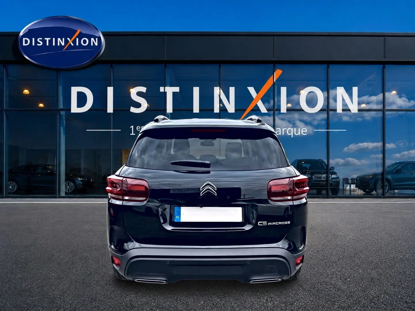 Vue arrière d'un Citroën C5 Aircross noir 2025 garé devant une vitrine avec logo Distinxion.