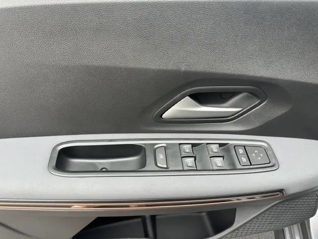 Panneau de porte côté conducteur de la Dacia Sandero Stepway TCE 110 Extreme Plus 2025 avec commandes des vitres et poignée grise.