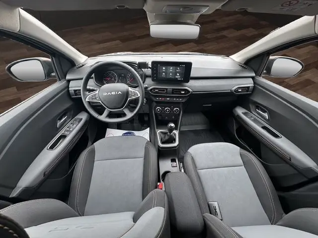 Vue intérieure avant de la Dacia Sandero Stepway TCE 110 Extreme Plus 2025, tableau de bord et sièges gris Urban, écran tactile central.