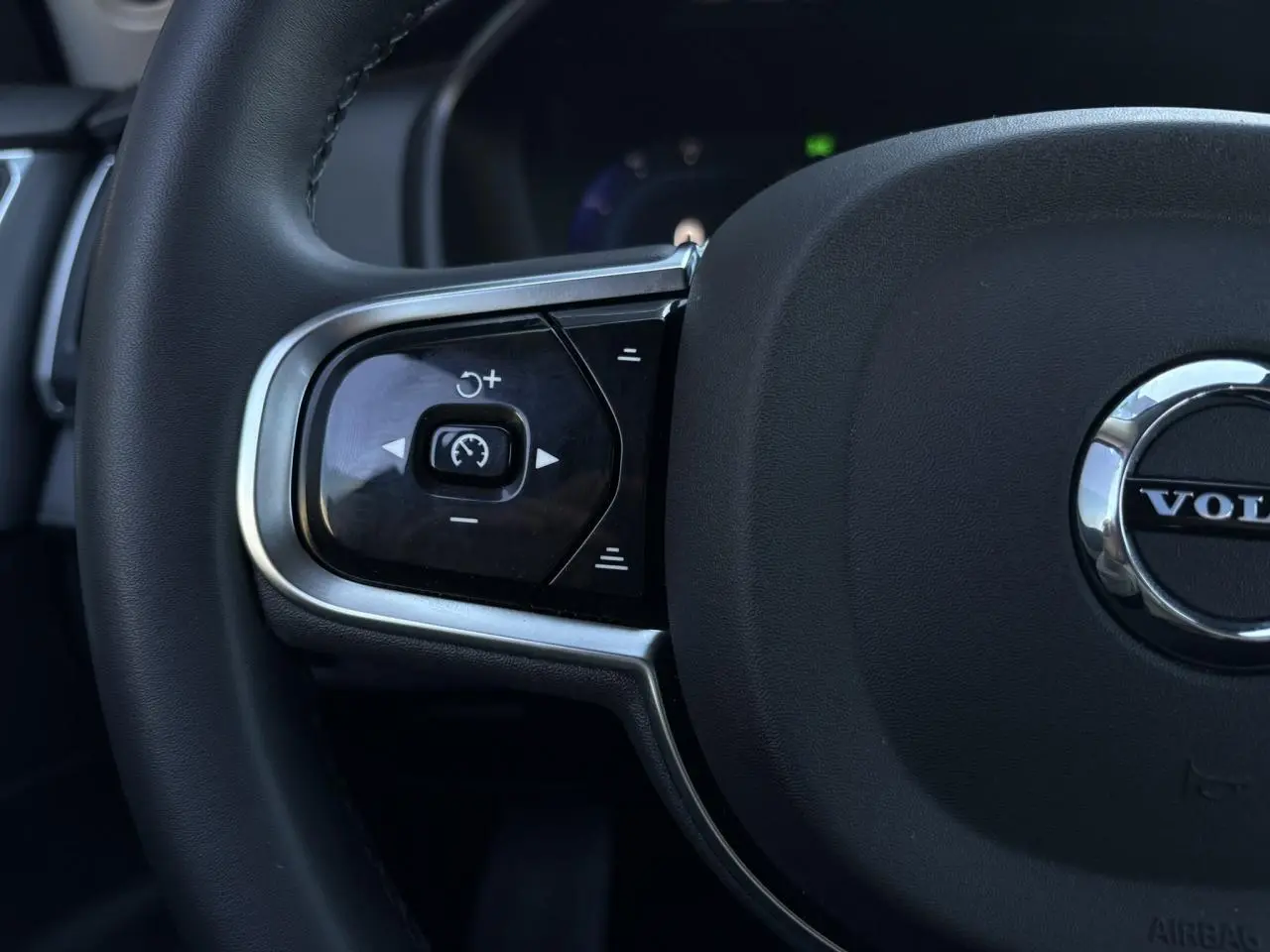 Gros plan sur la partie gauche du volant noir du Volvo XC90 T8 avec commandes de régulateur de vitesse intégrées.