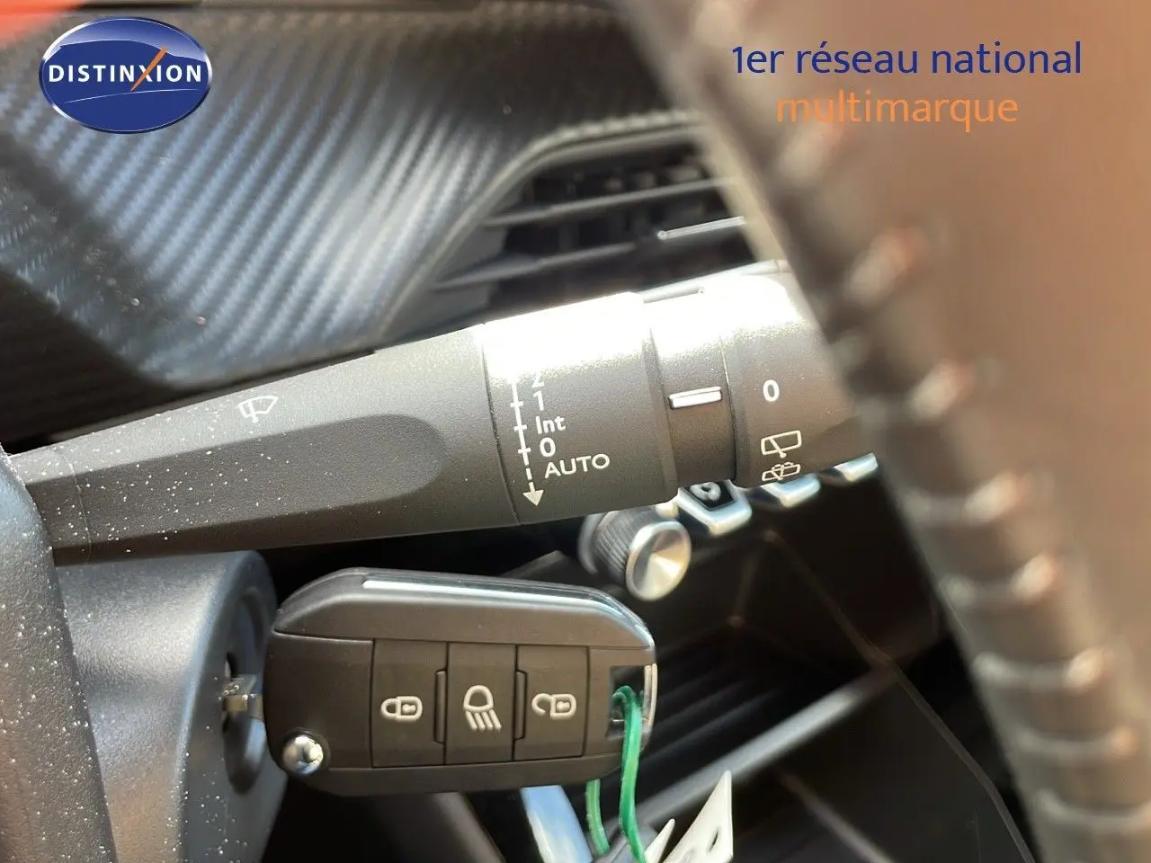 Gros plan sur la commande d'essuie-glace et la clé insérée dans le contacteur d'une Peugeot 2008 bleu Vertigo 2024.