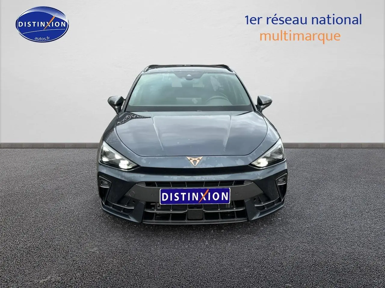 Vue de face d'une CUPRA Leon ST 1.5 etsi hybrid gris magnétique avec phares LED allumés et logo distinctif sur le capot.