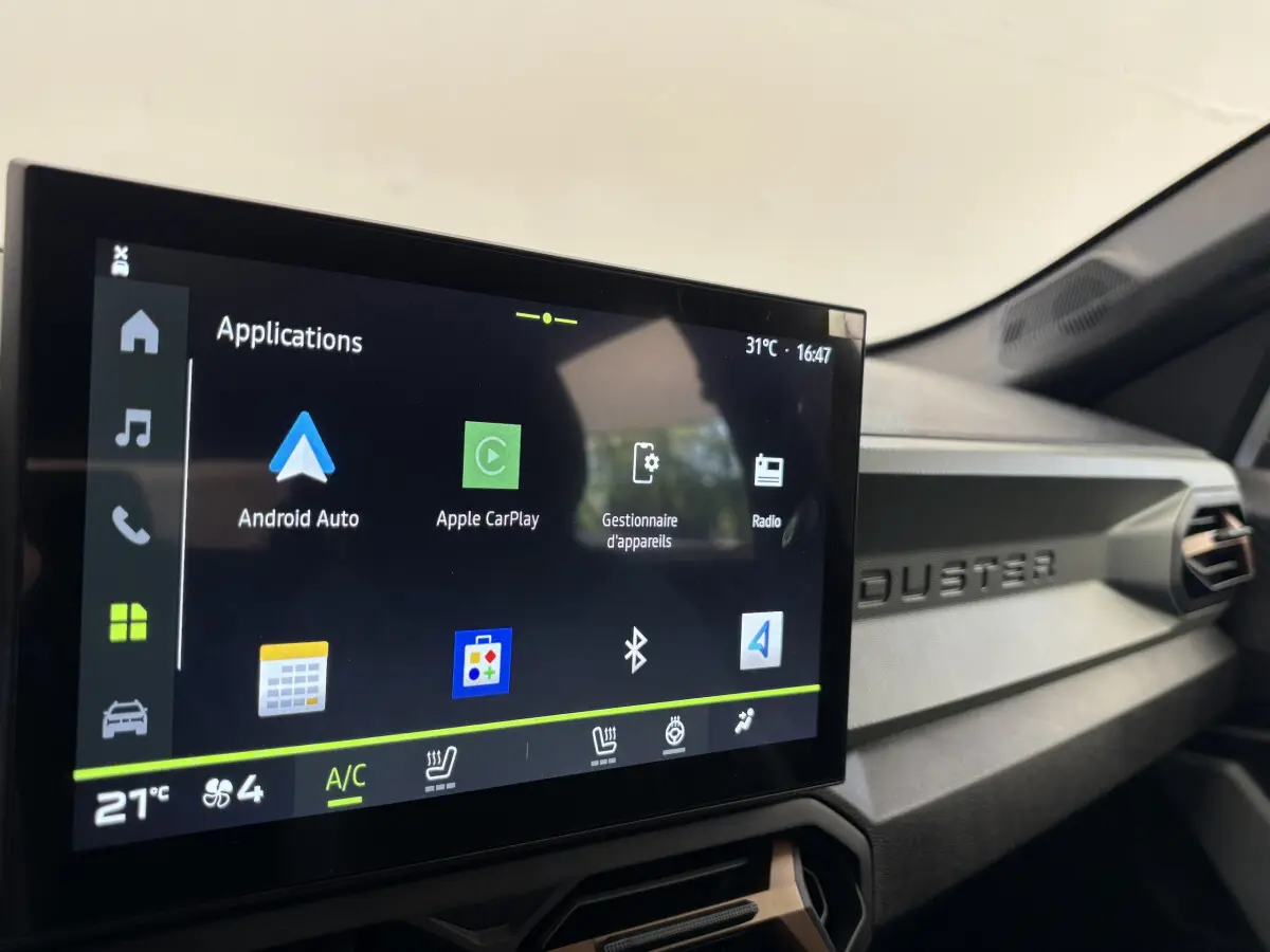 Écran tactile central du tableau de bord du Dacia Duster noir, affichant les applications Android Auto et Apple CarPlay.