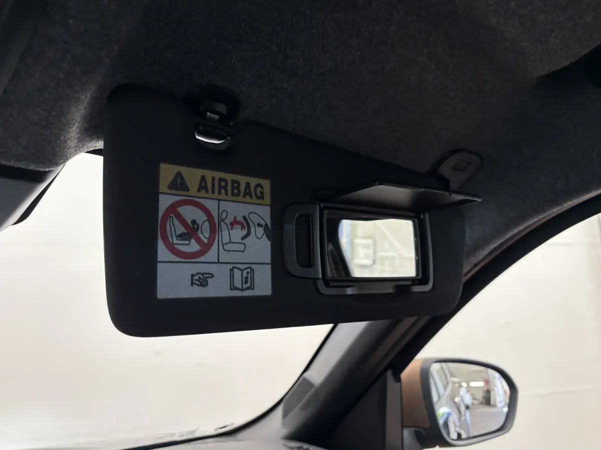Miroir de courtoisie ouvert sur pare-soleil côté conducteur dans un Dacia Duster noir 2025, vue intérieure rapprochée.