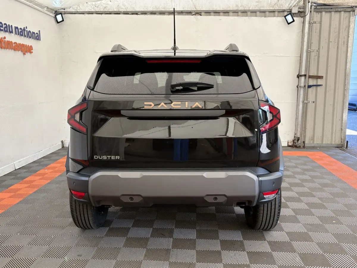 Vue arrière du Dacia Duster noir 2025, soulignant ses feux LED et son pare-chocs arrière gris robuste.