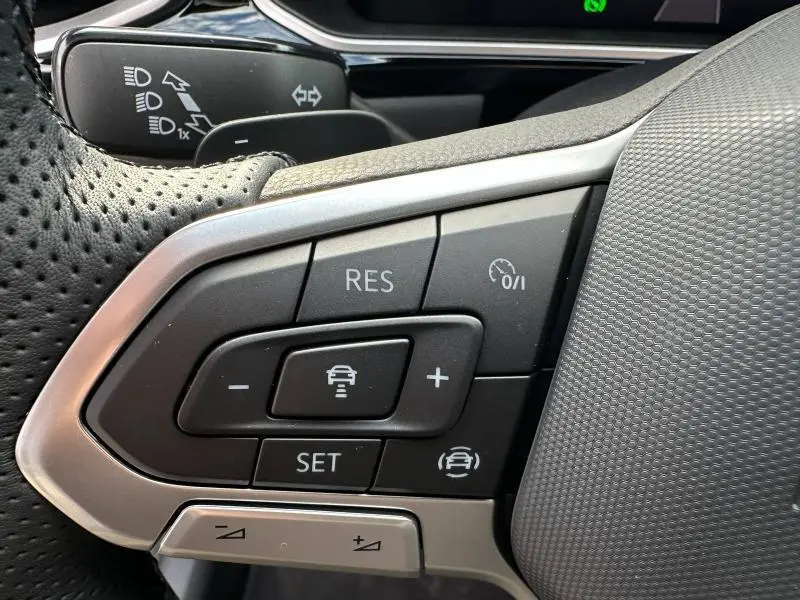 Gros plan sur les commandes au volant du Volkswagen T-Roc gris 2025, version R-Line Edition avec régulateur adaptatif.