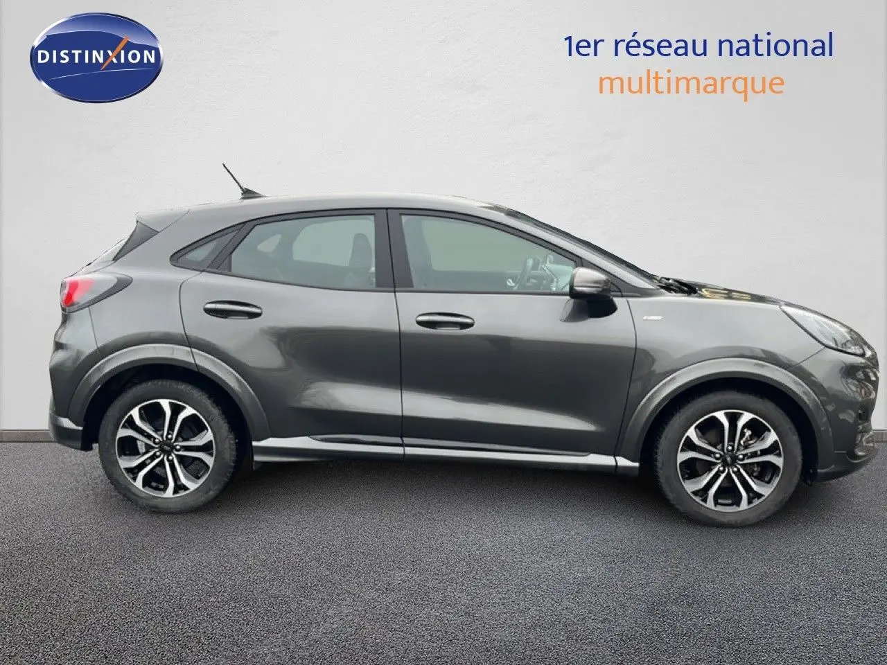Ford Puma gris magnétique vu de profil côté gauche, soulignant ses jantes alliage et lignes dynamiques.