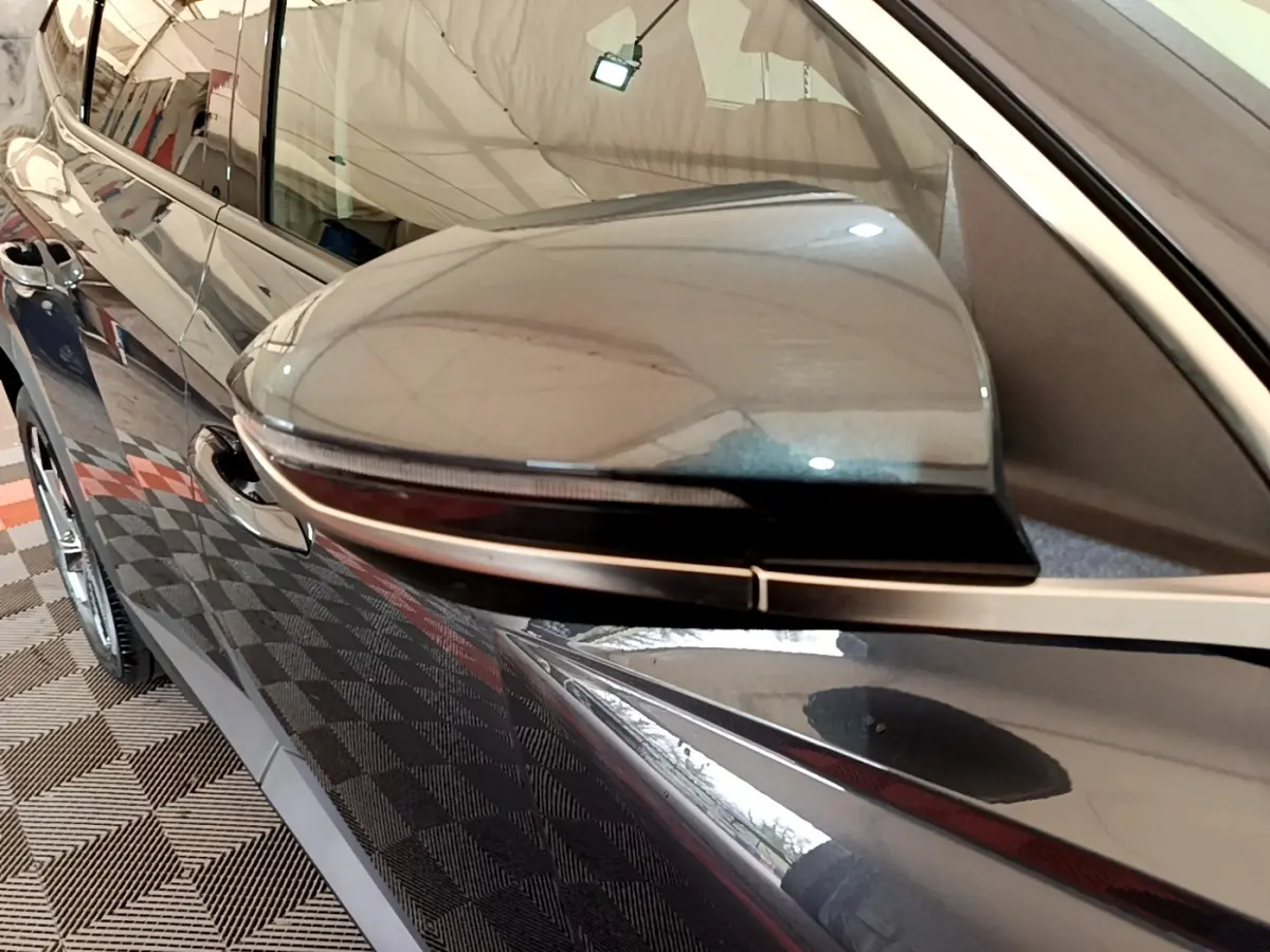 Gros plan sur le rétroviseur côté gauche gris foncé du Hyundai Tucson 2022 avec clignotant intégré.