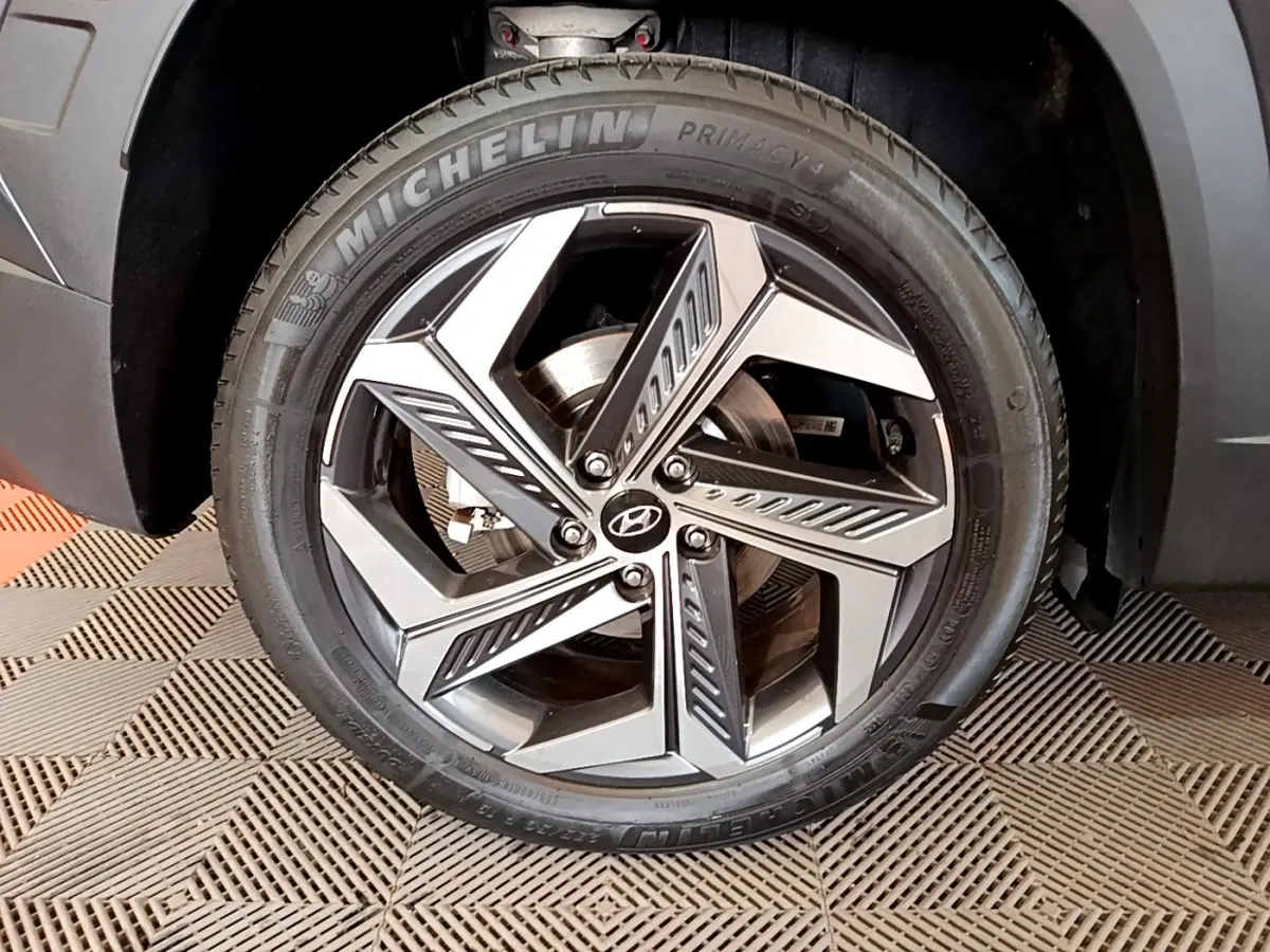 Gros plan sur la roue avant droite gris foncé du Hyundai Tucson 2022 avec jante alliage et pneu Michelin.