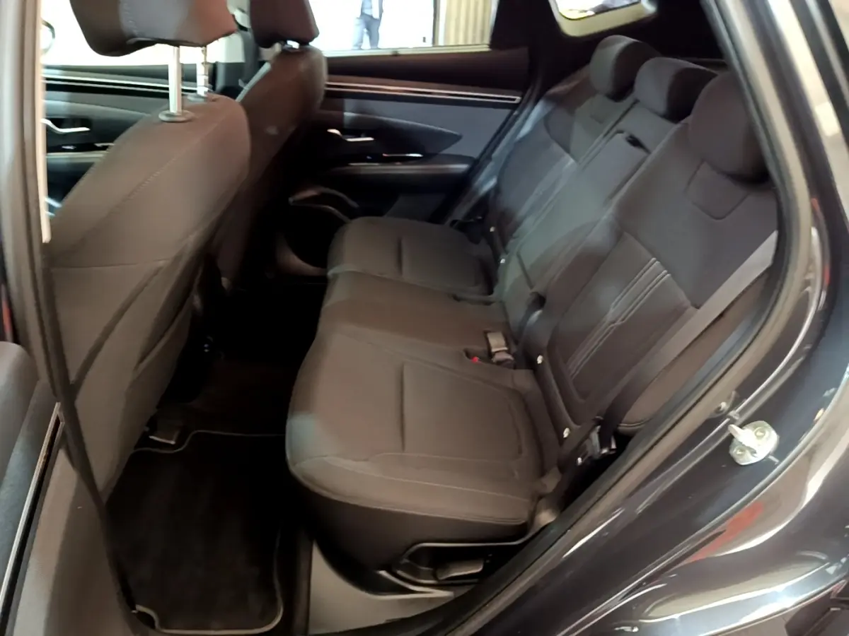 Vue intérieure côté droit des sièges arrière noirs du Hyundai Tucson 2022 gris foncé, avec ceinture de sécurité visible.