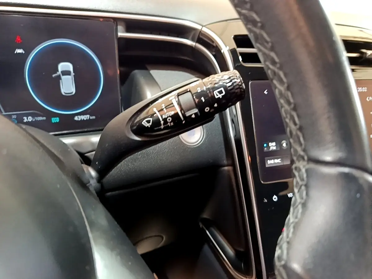 Gros plan sur la commande d’essuie-glace et le tableau de bord numérique du Hyundai Tucson gris foncé, intérieur moderne.
