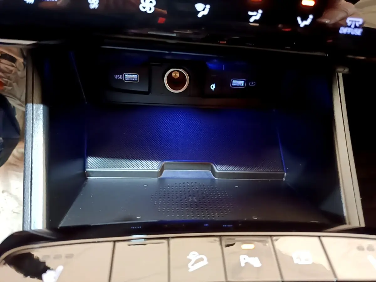 Gros plan sur la console centrale du Hyundai Tucson 2022, montrant les ports USB, prise 12V et recharge sans fil.