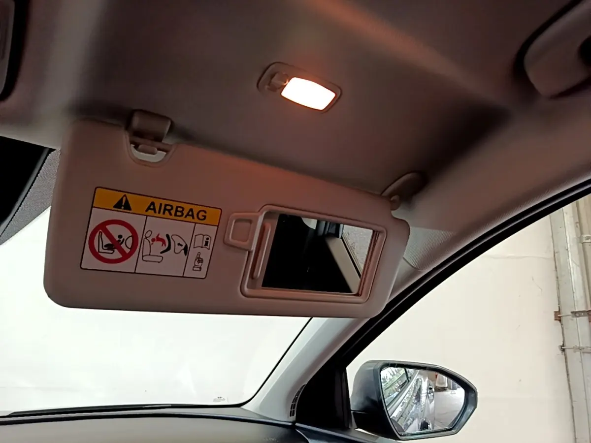 Détail intérieur du pare-soleil avec miroir et avertissement airbag, vue côté conducteur du Hyundai Tucson gris foncé.