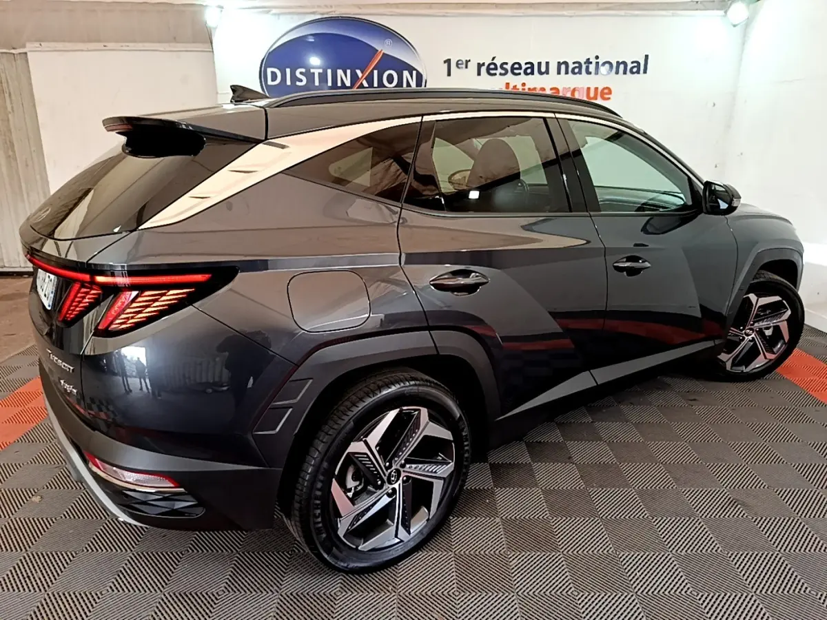 Vue 3/4 arrière droite du Hyundai Tucson gris foncé 2022 avec feux arrière LED et jantes alliage distinctives.