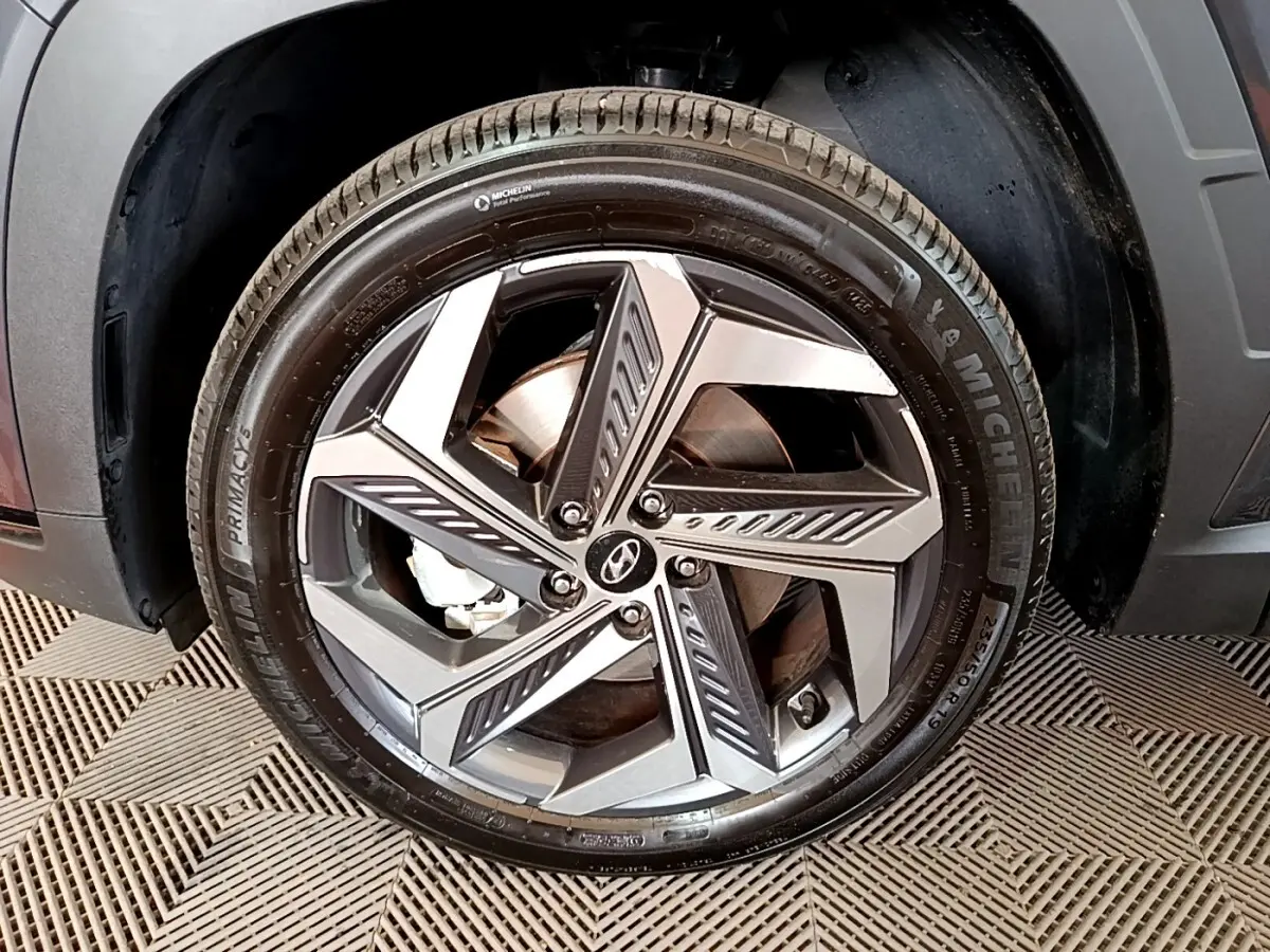 Gros plan sur la roue avant droite du Hyundai Tucson gris foncé, jante alliage à design moderne et pneu Michelin.