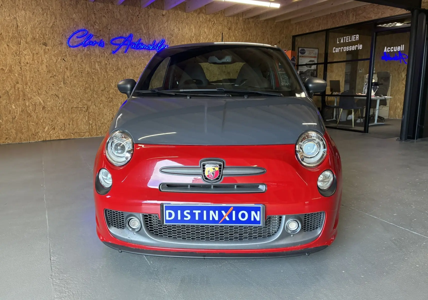 Vue de face de l'Abarth 500 Competizione 2016 bicolore rouge et gris avec logo Abarth et plaque Distinxion.