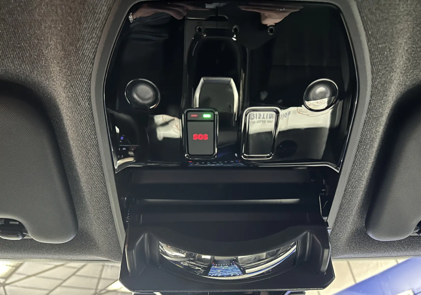 Vue intérieure du plafonnier noir brillant avec bouton SOS rouge et compartiment ouvert dans un Renault Austral blanc nacré.