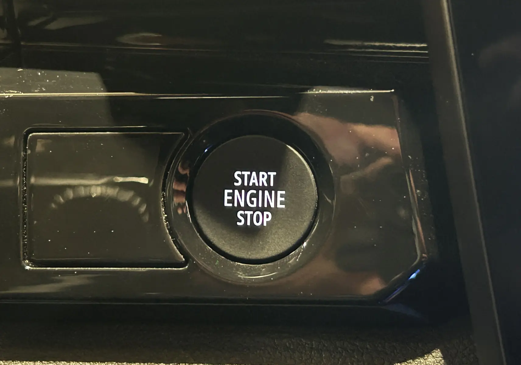 Bouton Start Engine Stop en gros plan sur la console intérieure noire d'un Renault Austral 2024.