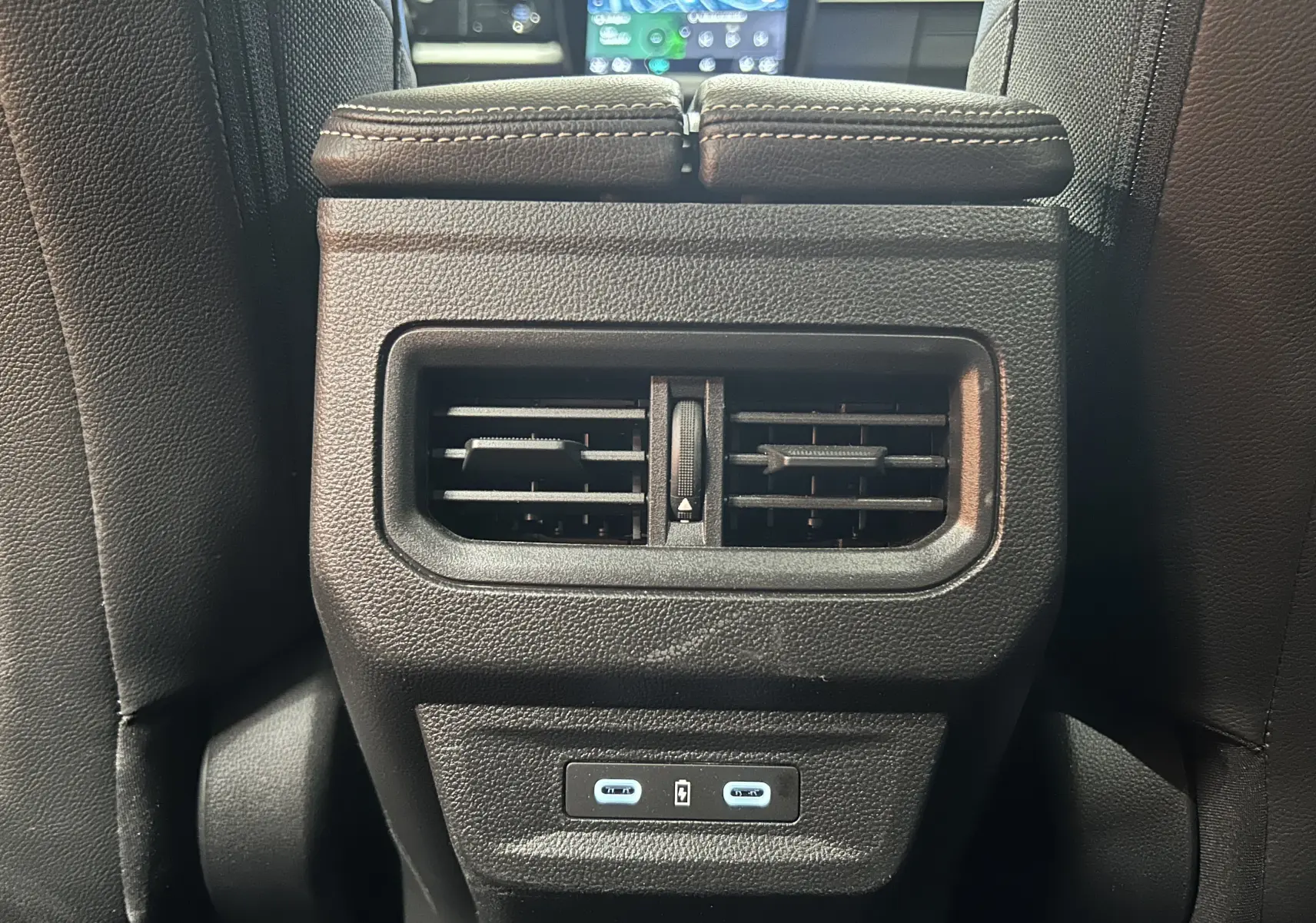 Gros plan sur la sortie d’air arrière noire et les deux ports USB-C du Renault Austral blanc nacré, intérieur cuir noir.