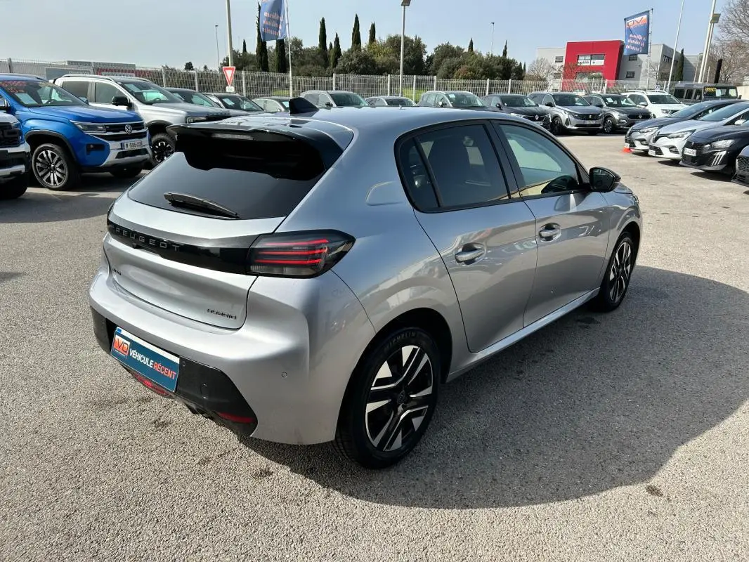 Peugeot 208 Hybrid 110 gris vue 3/4 arrière droit, feux arrière LED et jantes alliage distinctives visibles.