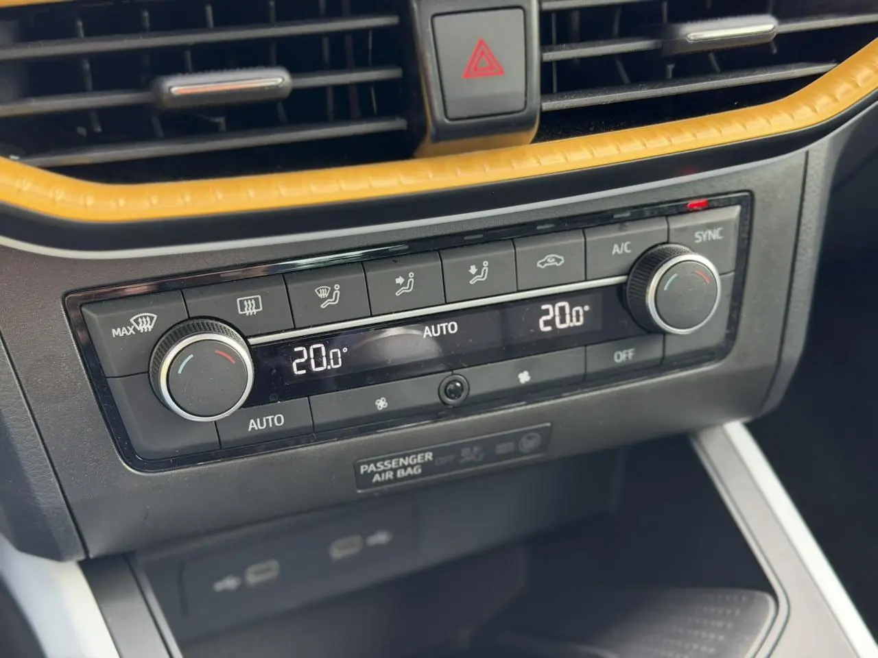Gros plan sur la console centrale de la SEAT Arona TSI 115 Style 2025, montrant la climatisation automatique bi-zone avec cadre jaune.